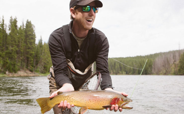 Man engaged in recreational fishing by the serene lake, showcasing the adventurous spirit ideal for Roark's outdoor lifestyle enthusiasts.